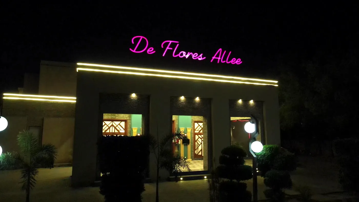 De Flores Allee at night, the pink sign lit over the entrance